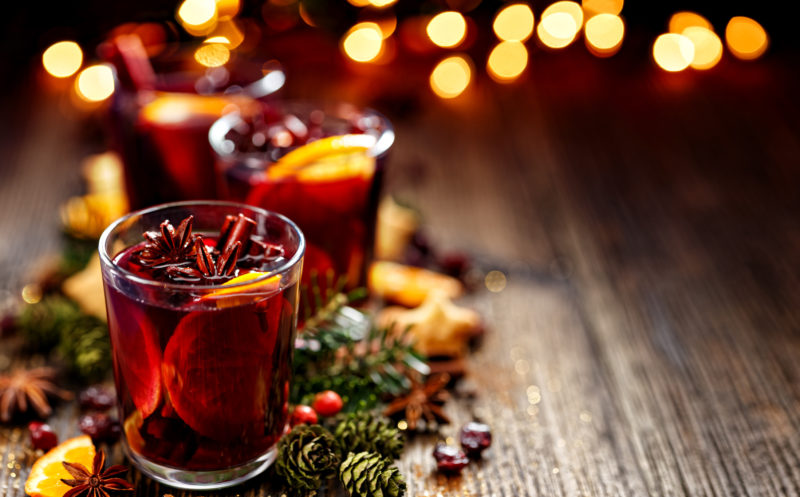 Red mocktail drink in a glass, with orange, cinnamon, star anise.