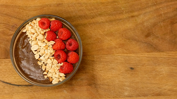 chocolate smoothie bowl with raspberries and peanuts