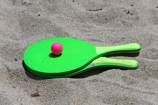 paddles and bouncy ball on the beach