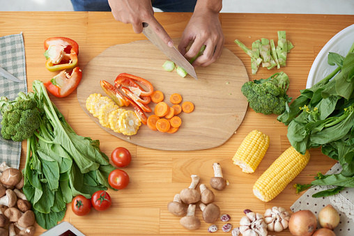 person cutting vegetables on a cutting board
