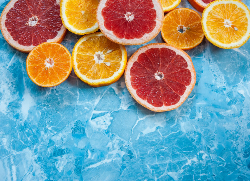 grapefruit, orange and tangerine on blue background