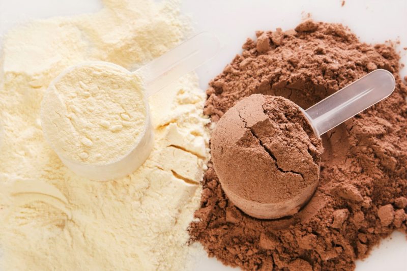 chocolate and vanilla protein powder in plastic scoops