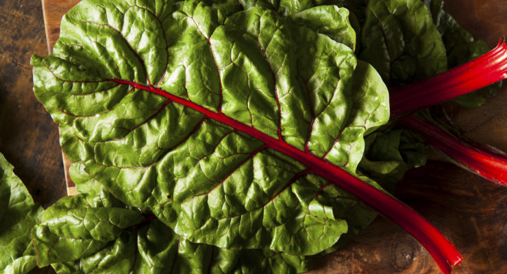 red chard leaves on a wooden cutting board