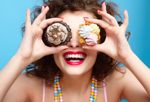 woman holding desserts over eyes