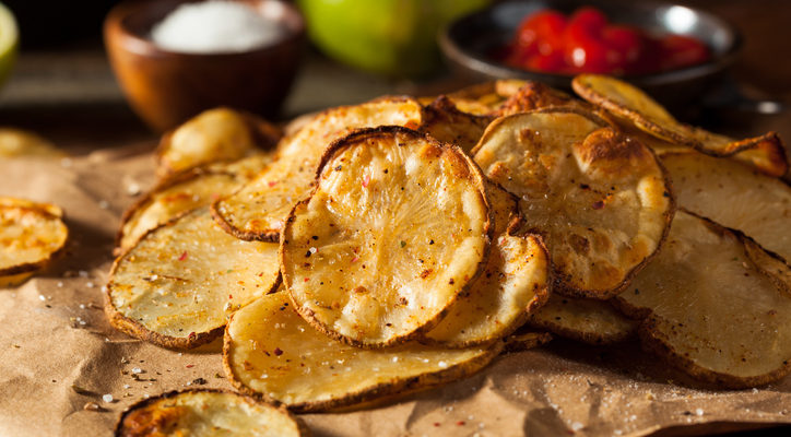 homemade potato chips with spices over brown paper
