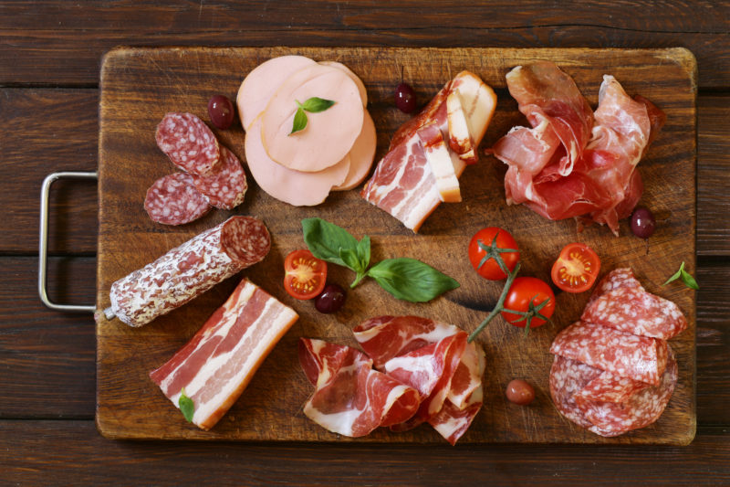 assorted deli meats on a cutting board