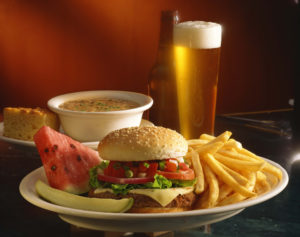 soup, beer, burger with fries with a pickle and watermelon slice