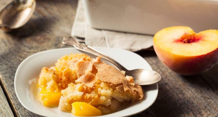 Slice of peach cobbler served on a dish.