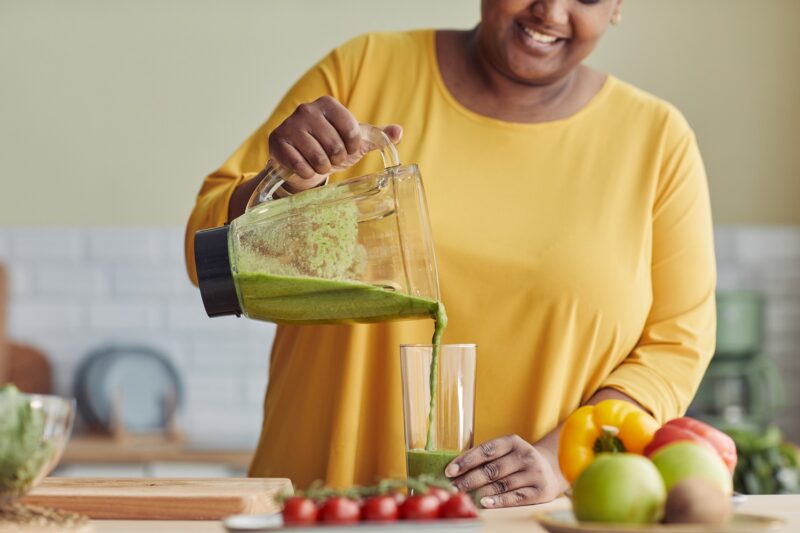 woman making healthy protein shake or smoothie
