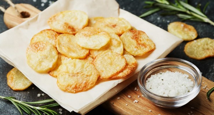 Homemade salt and vinegar chips with salt and rosemary in the background