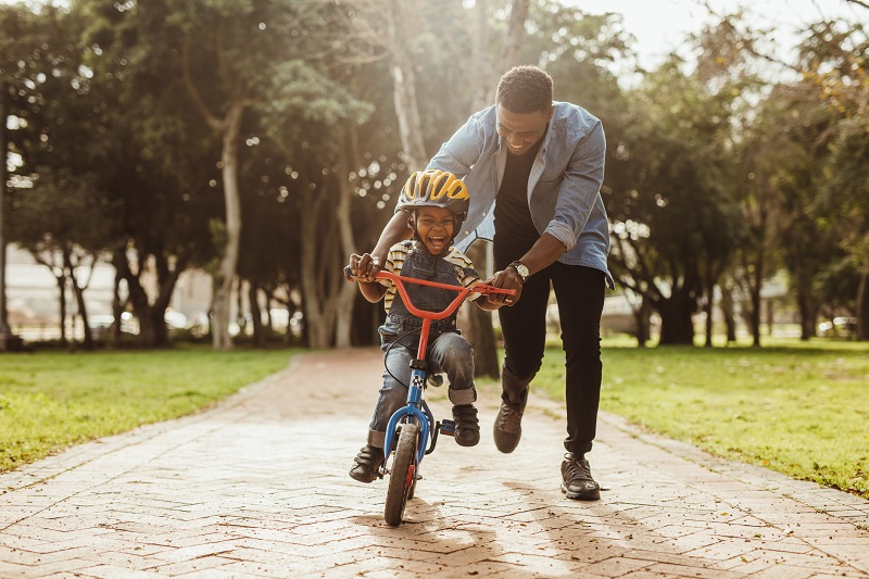 father teaching son how to bike