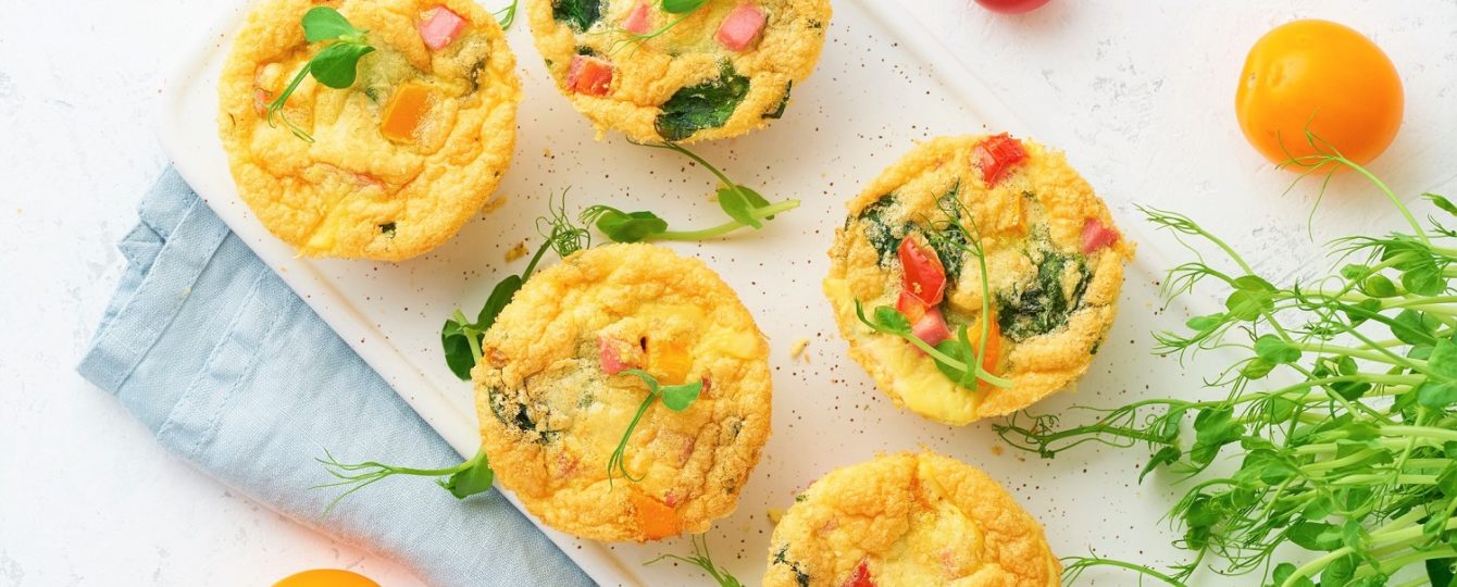 egg muffins on a cutting board with tomatoes