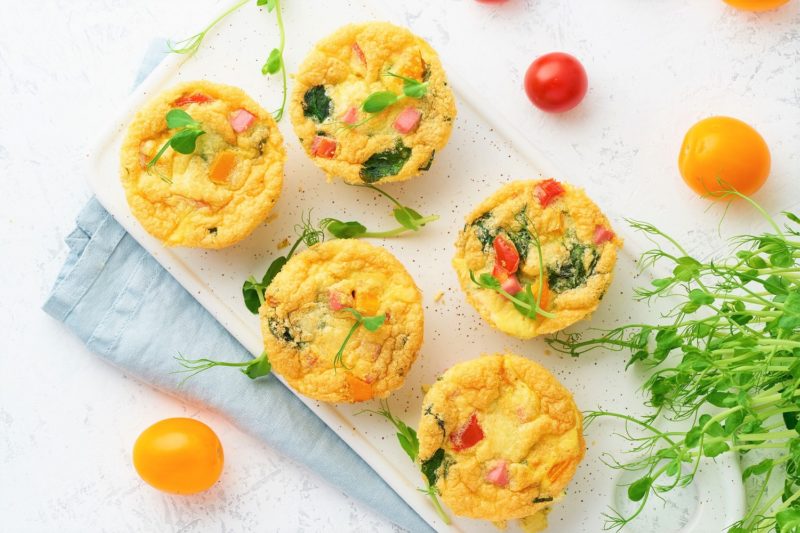 egg muffins on a cutting board with tomatoes
