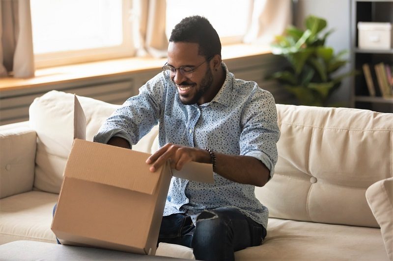 man opening a box on his couch