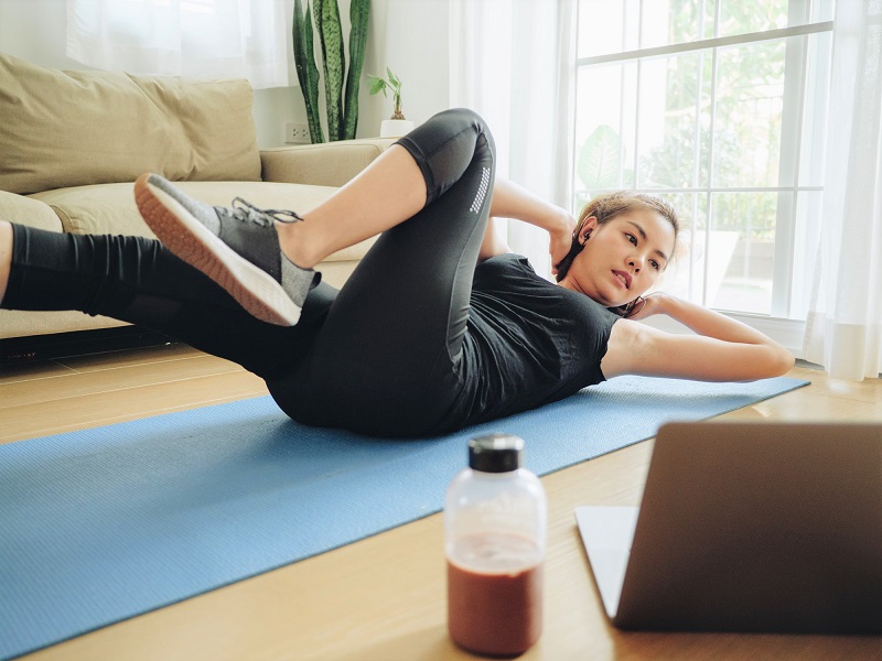 woman exercising on a yoga mat at home to help stress