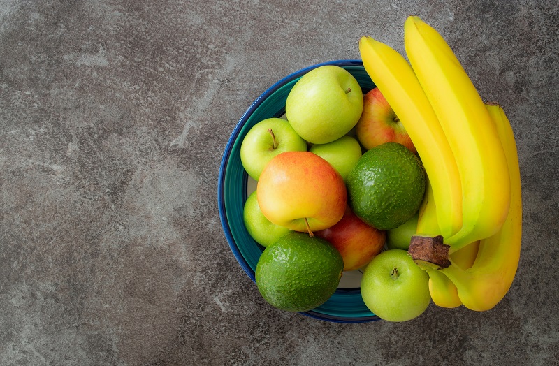 Bowl of fruits (apples and bananas) on the counter.