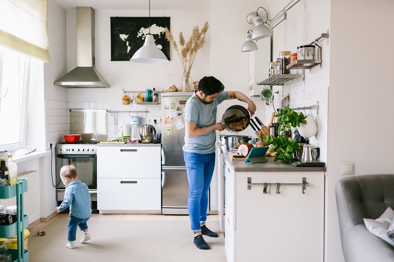 Healthy recipes, Dad cooking in the kitchen, while a toddler plays nearby. weight loss tips for busy dads