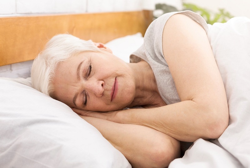 Older woman sleeping in bed. pear shaped body fat loss tips