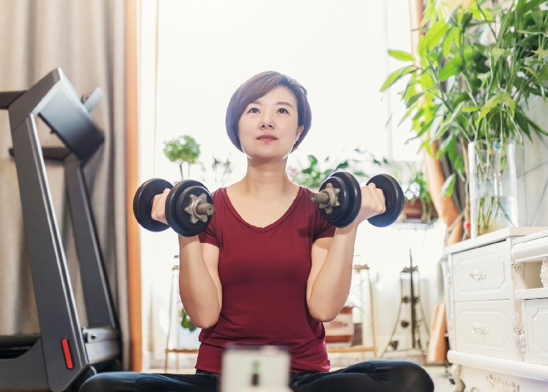 woman working out at home with dumbbells