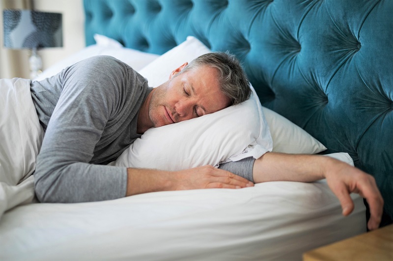 a man sleeping in a bed. losing weight after 40