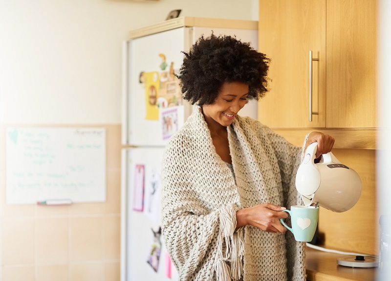 Shot of a young woman making a cup of tea at home in the morning. metabolism boosting tips for women