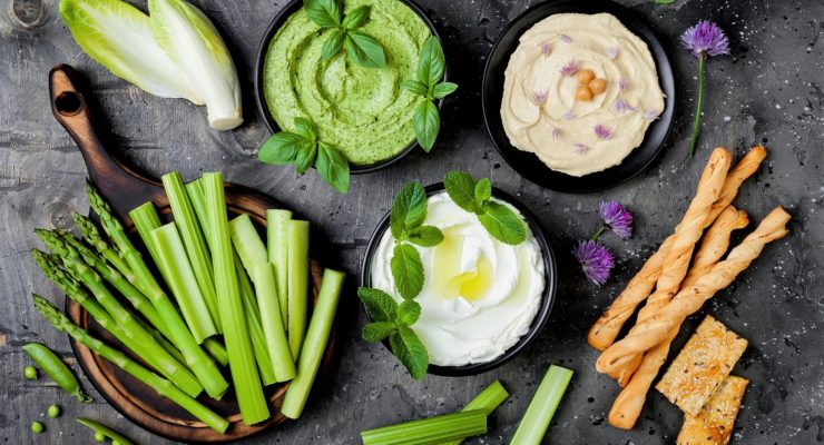 a healthy appetizer spread with assorted dips and veggies