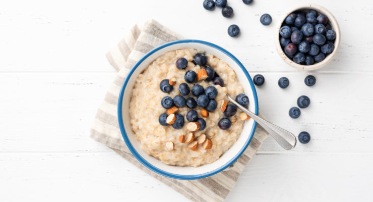 a bowl of oatmeal with blueberries to help target belly fat