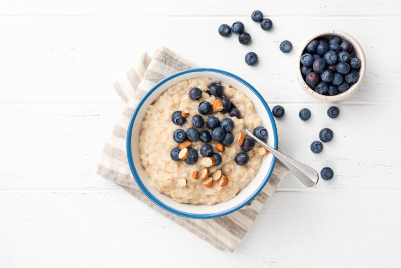 a bowl of oatmeal with blueberries to help target belly fat
