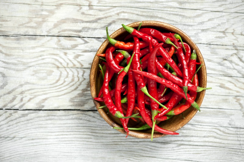fresh red chili peppers in a small bowl. metabolism boosting foods