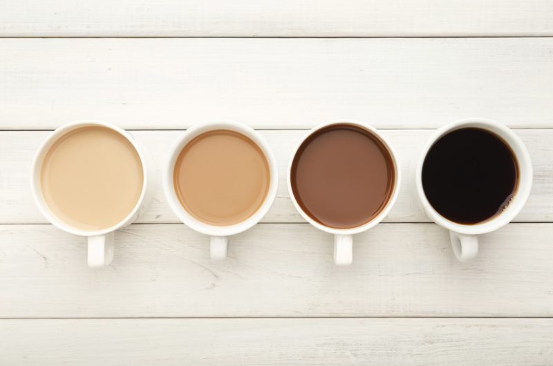 a line up of four cups of coffee, with different levels of milk. Does coffee boost metabolism?