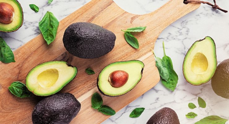 freshly cut avocados on a cutting board. metabolism boosting foods