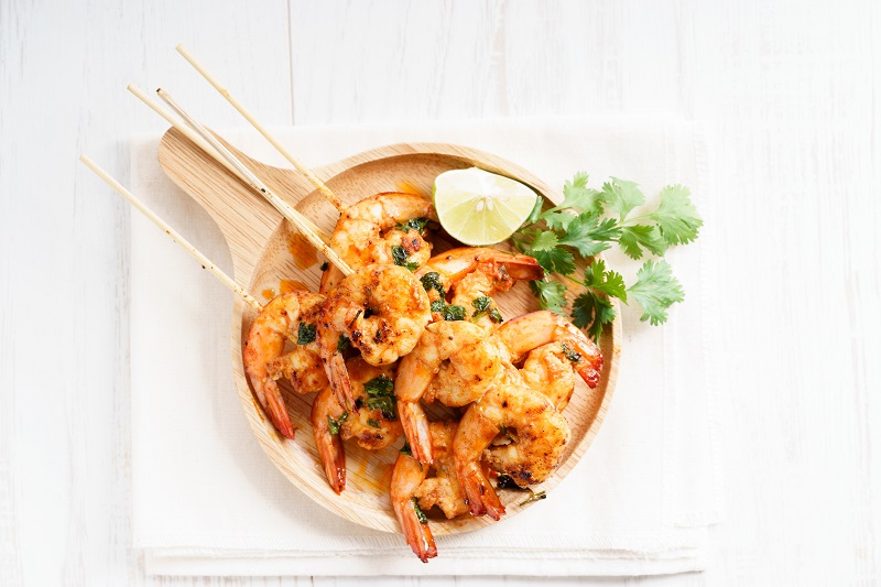Prawns on a skewer with garnish and lime