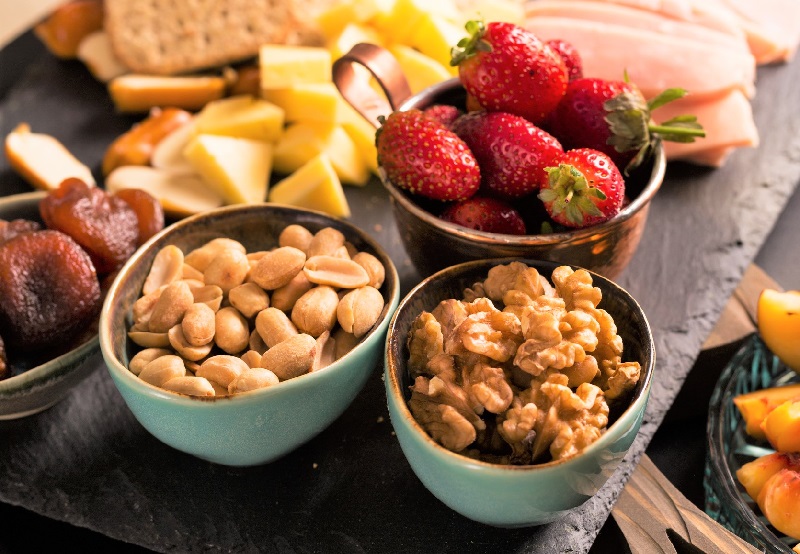 a close up of appetizers with cheese, fruits and nuts