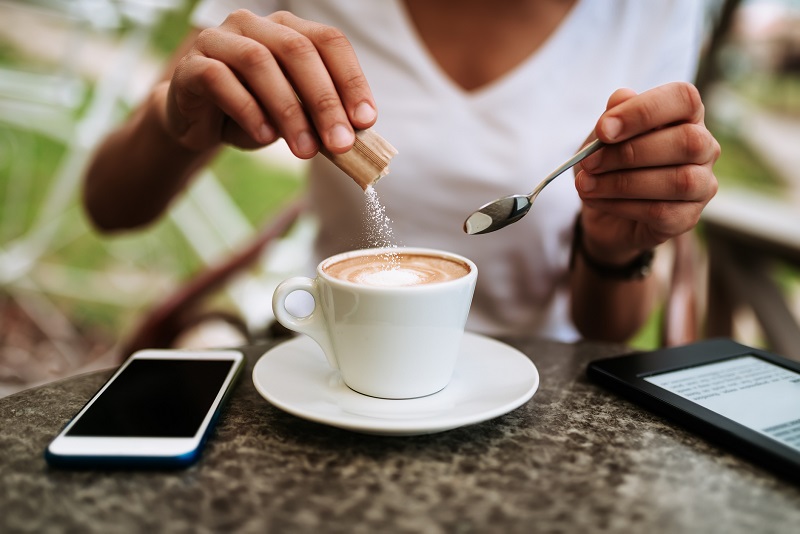 woman pouring an unlimited Natural Zero-Calorie Sweetener in coffee