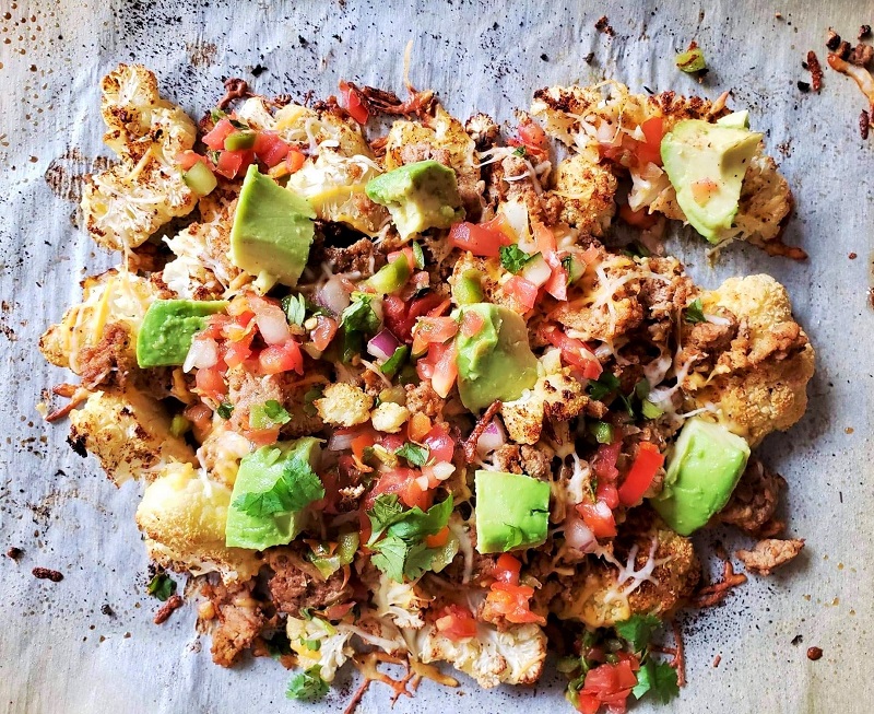 cauliflower nacho meal, with avocado, turkey, tomato, onions, and other vegetables
