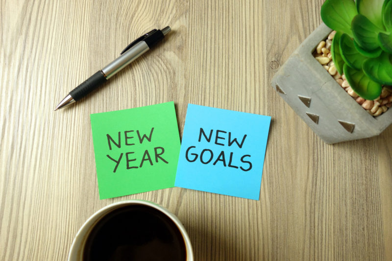 notes with new year new goals written on them. new year's resolutions.