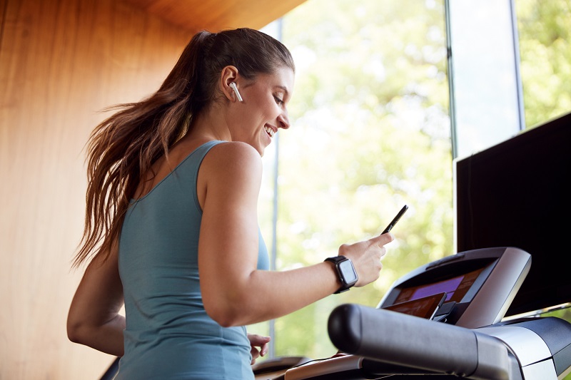 a woman listening to music while working out at the gym