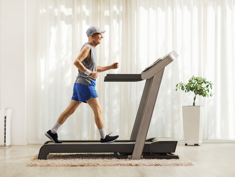 elderly man working out on a treadmill at home