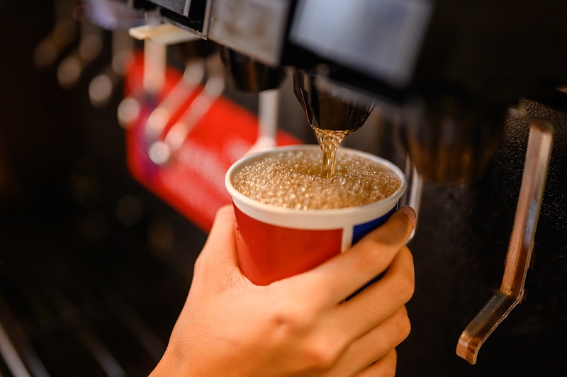 soda being poured into a to go cup
