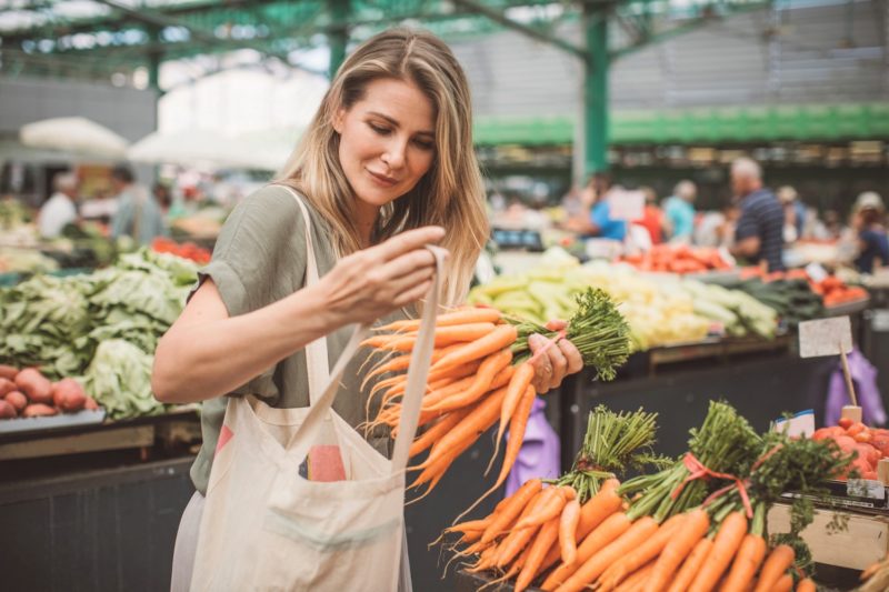 woman buying carrots at a farmers market