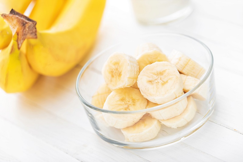 sliced bananas in a glass bowl on a white table