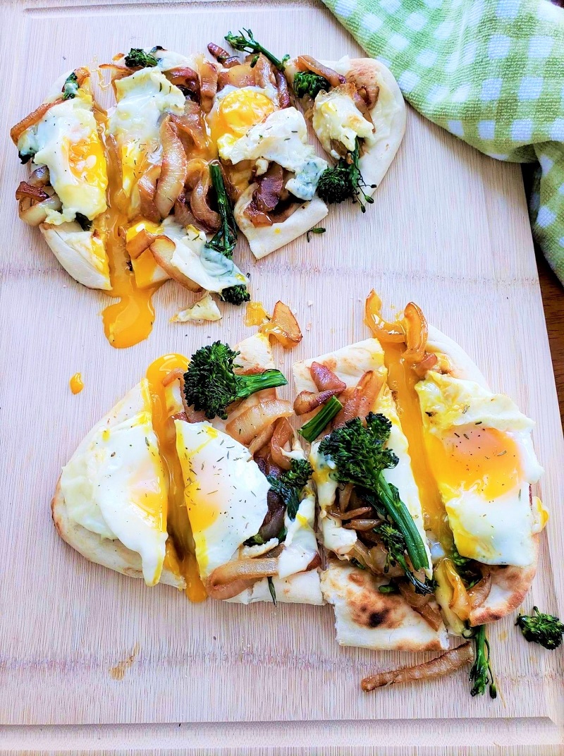 French Onion Breakfast Flatbread on naan with eggs, swiss cheese and broccolini