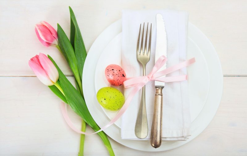 brunch plate with pink Easter decorations of colored eggs and pink tulips