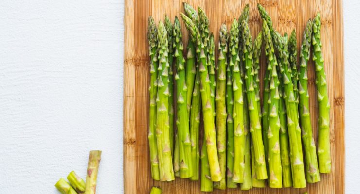 fresh in season asparagus on a wooden cutting board