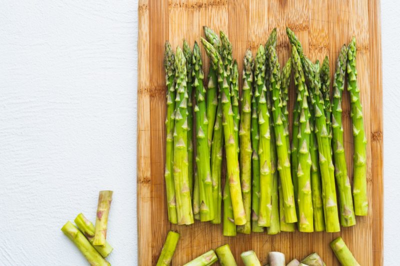 fresh in season asparagus on a wooden cutting board