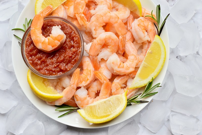 shrimp cocktail with lemon wedges and thyme