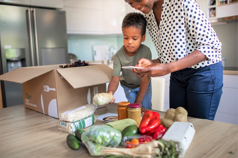 Woman and Boy unpacking groceries from a box