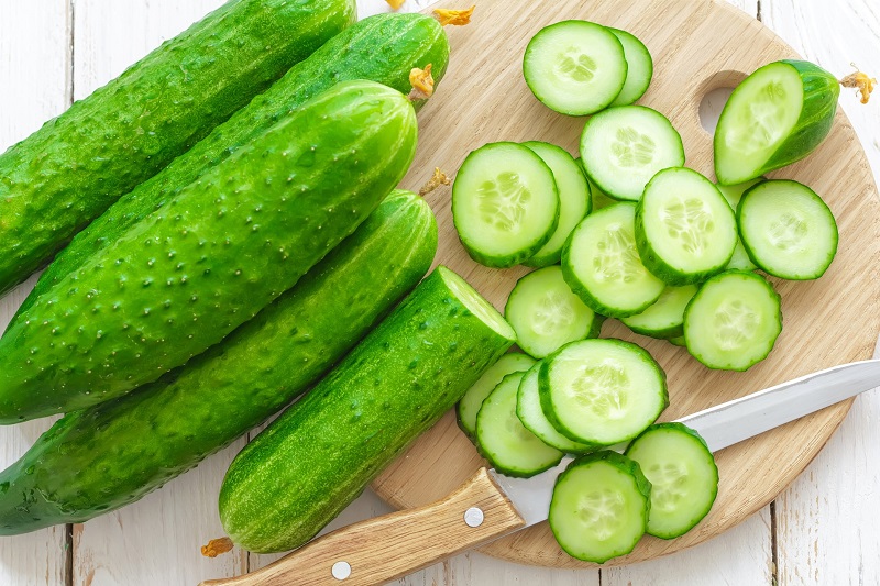 fresh cucumbers sliced on a cutting board