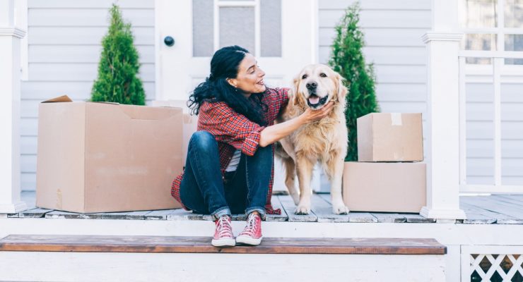 a woman and a dog sitting on a porch with boxes of food