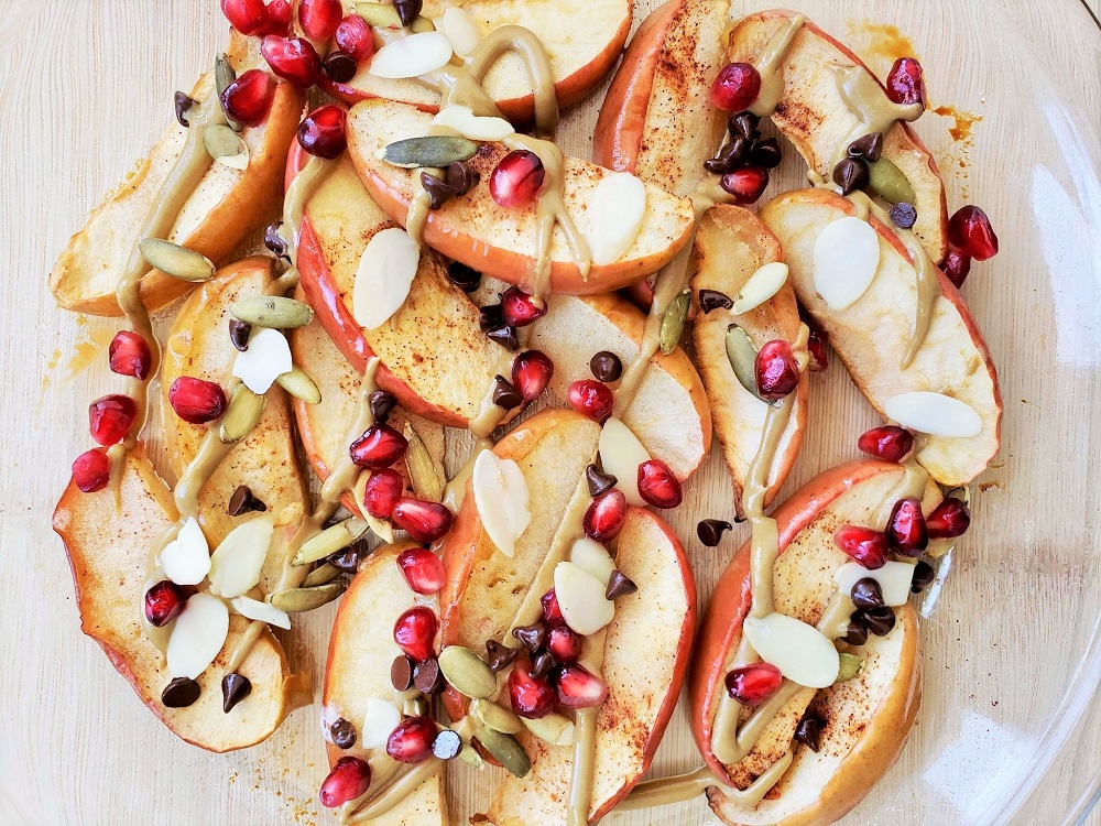 Baked Apple Nachos with nut butter, seeds, chocolate chips and pomegranate seeds